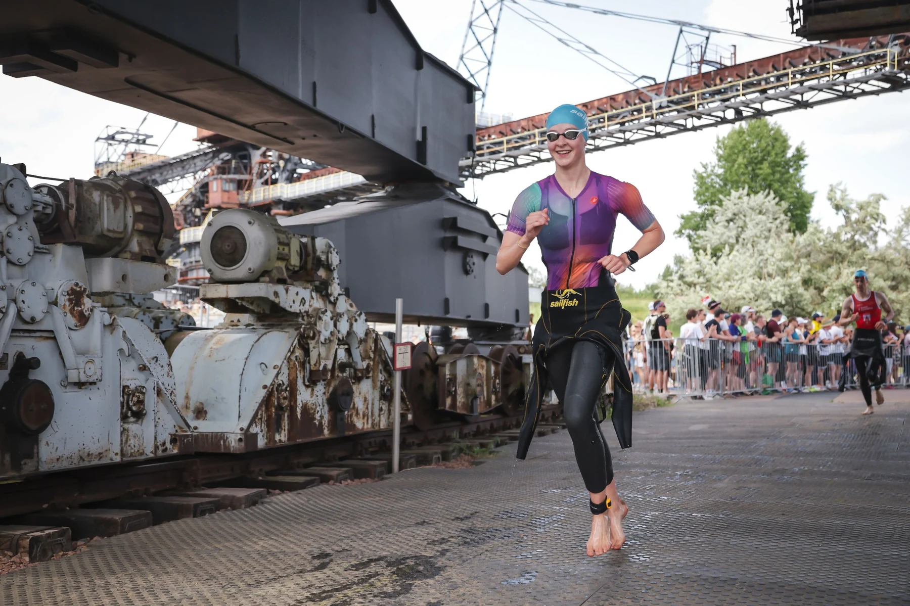 Triathletin läuft aus dem Schwimmen in Richtung Wechselzone